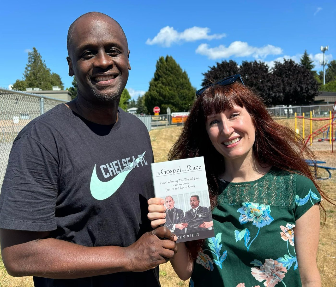Ken Riley and the artist holding a copy of The Gospel and Race